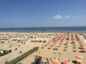 a beach filled with lots of umbrellas and the ocean at Hotel Cosmopolita in Rimini