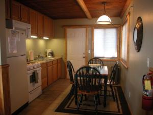 una cucina con tavolo, sedie e frigorifero di Moonridge Ski Pad a Big Bear Lake