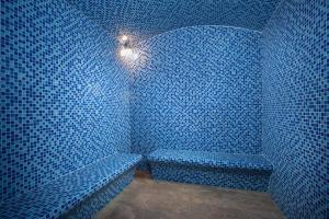 a blue room with a bench in the corner at Somerset Harmony City Wuxi in Wuxi