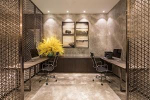 an office with two desks with two computers and chairs at Somerset Harmony City Wuxi in Wuxi