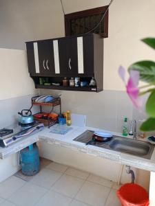 a kitchen counter with a sink and a stove at Twins Homestay in Canggu