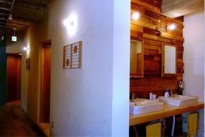 bagno con 2 lavandini e parete in legno di Tomarotto Hostel a Takayama Altre 23 foto