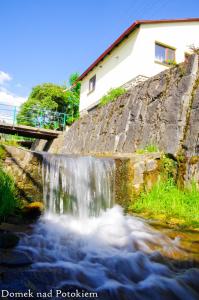 een kleine waterval aan de kant van een rivier bij Domek nad potokiem in Kluszkowce