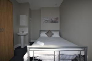 a small bedroom with a bed and a sink at Western Hill in Sunderland