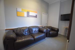 Western Hill في سندرلاند: غرفة معيشة مع أريكة جلدية وتلفزيون