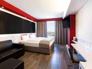 um quarto de hotel com uma cama e um sofá em DORMERO Hotel Stuttgart em Estugarda mais 36 fotografias