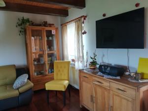 ein Wohnzimmer mit einem Flachbild-TV und einem Stuhl in der Unterkunft Kuća Za Odmor Barbara in Donja Stubica