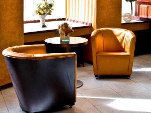 two chairs and a table in a room at Hotel Harmony in Prague