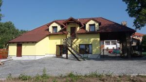 una casa gialla con tetto marrone di Penzion AMÁLKA Černín a Zdice