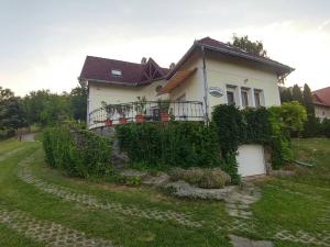 a house with ivy growing on the side of it at Szigligeti Panoráma Apartmanház in Szigliget