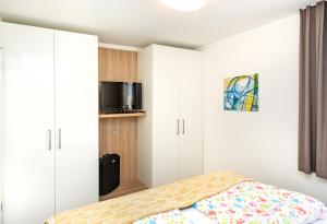 Schlafzimmer mit weißen Schränken und einem Bett in der Unterkunft Ferienresidenz "Seelust" Whg 5 in Waren (Müritz)