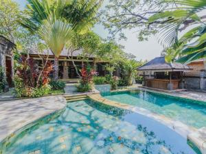 a swimming pool in front of a house with a gazebo at Villa Victoria Bali in Canggu
