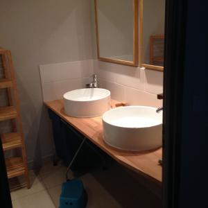 W łazience znajduje się biała umywalka i lustro. w obiekcie Rue des Sophoras w mieście Luc-en-Diois