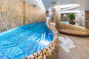 uma grande piscina com duas cadeiras num quarto em Wellton Riga Hotel & SPA em Riga