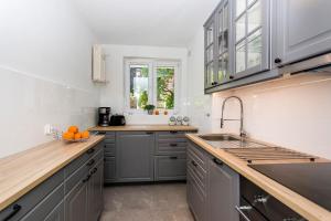 a kitchen with gray cabinets and a sink at Sunny Suite in Center of Sopot in Sopot