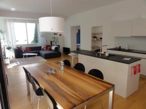 a kitchen and living room with a wooden table in a room at Paracelsus Locarno Stadt Wohnung in Locarno +12 photos