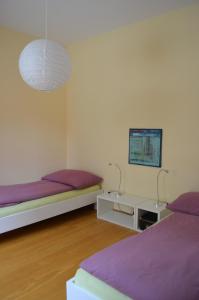 1 Schlafzimmer mit 2 Betten und einem TV an der Wand in der Unterkunft Paracelsus Locarno Stadt Wohnung in Locarno
