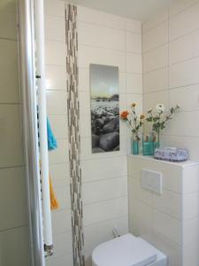 uma casa de banho com WC e flores em Ferienwohnung Seepferdchen em Bremerhaven