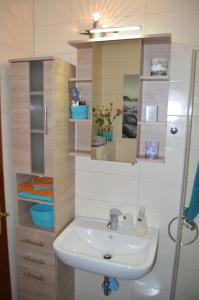 y baño con lavabo y espejo. en Ferienwohnung Seepferdchen, en Bremerhaven