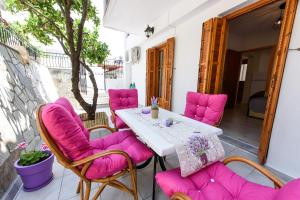 a table and chairs on a patio with pink cushions at Oasis 2 in Neo Klima