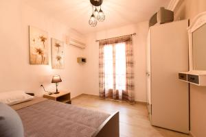 a bedroom with a bed and a refrigerator and a window at Oasis 2 in Neo Klima