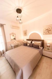 a bedroom with a large bed and a chandelier at Oasis 2 in Neo Klima
