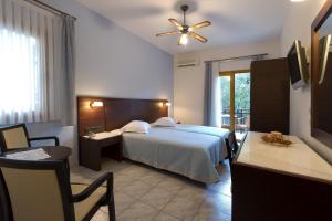 Schlafzimmer mit einem Bett, einem Tisch und einem Fenster in der Unterkunft Villa Coralli in Parga