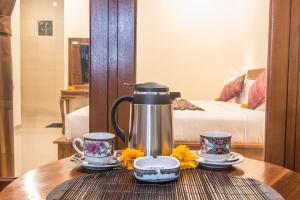 a coffee pot and two cups on a table at Pondok Badri in Ubud