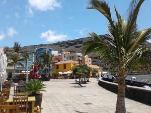 una palmera en una ciudad con una montaña en el fondo en il GABBIANO, en Los Cancajos