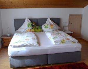 a bed with two pillows on top of it at Pension Mozart in Ottobeuren