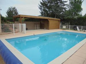 a swimming pool with a pavilion next to a building at Gites de Frans in Frans