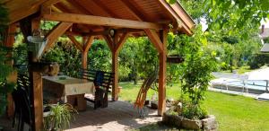 a wooden pavilion with a table in a garden at Magdalena Apartmanház in Keszthely