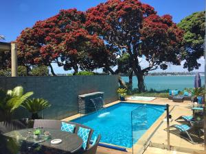 una piscina en un patio con mesa y sillas en Sea view guest house, en Auckland