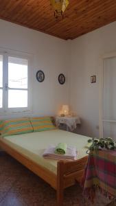 a bedroom with a large bed with a window and a table at P & G Apartment in Pámfylla