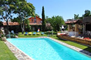 a swimming pool in the yard of a house at Hospedium Hacienda Las Cavas in Olmedo
