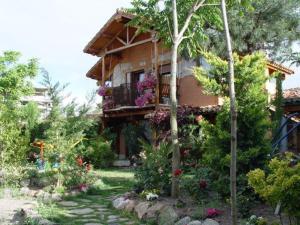 una casa con flores y plantas delante de ella en Hospedium Hacienda Las Cavas, en Olmedo