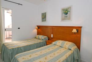 Cama ou camas em um quarto em Apartamentos HC Burriana Playa