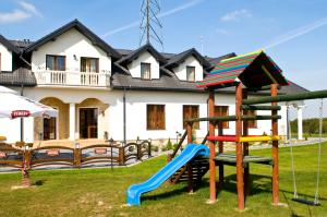 a playground in a yard in front of a house at Hotel Gościniec Horyzont in Zemborzyce Tereszyńskie