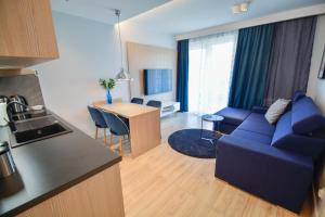 a kitchen and a living room with a couch and a table at Apartamenty na Wyspie - Villa Pegaz - Parking in Świnoujście