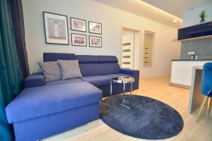 sala de estar con sofá azul y mesa en Apartamenty na Wyspie - Villa Pegaz - Parking, en Świnoujście