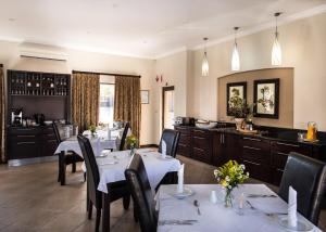 a restaurant with tables and chairs and a kitchen at Heidelberg Kloof Lodge in Heidelberg