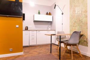 a kitchen with a table and chairs in a room at Baltic Design Apartments with free Parking in Rīga