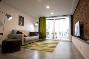 Una sala de estar con un sofá y un televisor. en Casa Nutrizione Apartment, en Catania