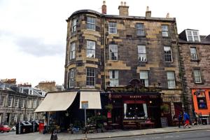 a large brick building with a store in front of it at Bright and cosy 2BR Apt with workspace in New town, 5mins to Princes St in Edinburgh