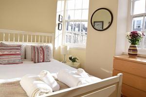 - une chambre avec un lit blanc et des serviettes dans l'établissement Bright and cosy 2BR Apt with workspace in New town, 5mins to Princes St, à Édimbourg