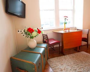 a living room with a vase of flowers and a table at JOIVY Bright and cosy 2BR Apt with workspace in New town, 5mins to Princes St in Edinburgh