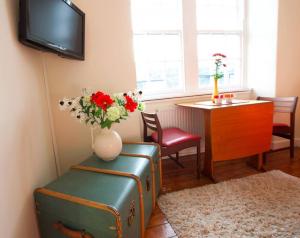 a living room with a vase of flowers and a table at Bright and cosy 2BR Apt with workspace in New town, 5mins to Princes St in Edinburgh