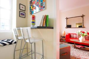a living room with a bar and a red couch at Bright and cosy 2BR Apt with workspace in New town, 5mins to Princes St in Edinburgh