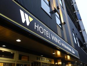 大阪市にあるホテルウィングインターナショナル セレクト大阪梅田のホテルの翼の看板が貼られた建物