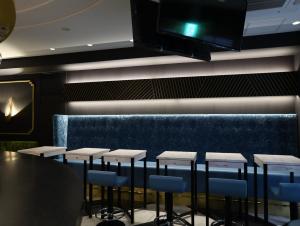 a dining room with a table and stools and a tv at Hotel Wing International Select Osaka Umeda in Osaka